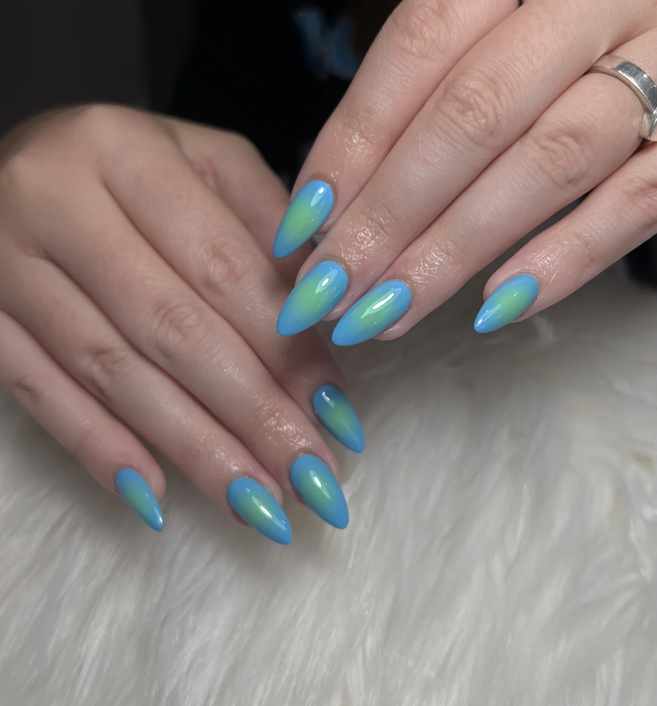 Sky blue almond nails with airbrushed neon green ombré