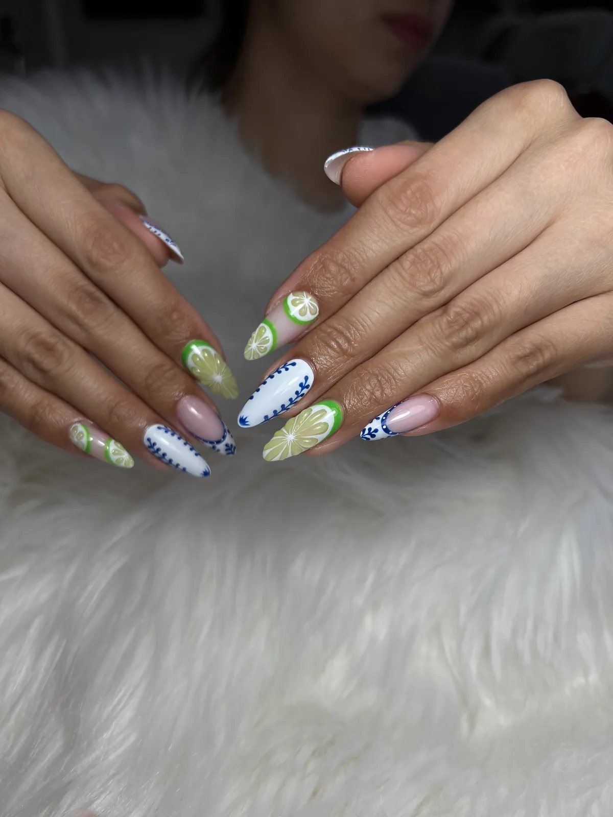 Second angle of cobalt porcelain almond nails with painted lime slice accents