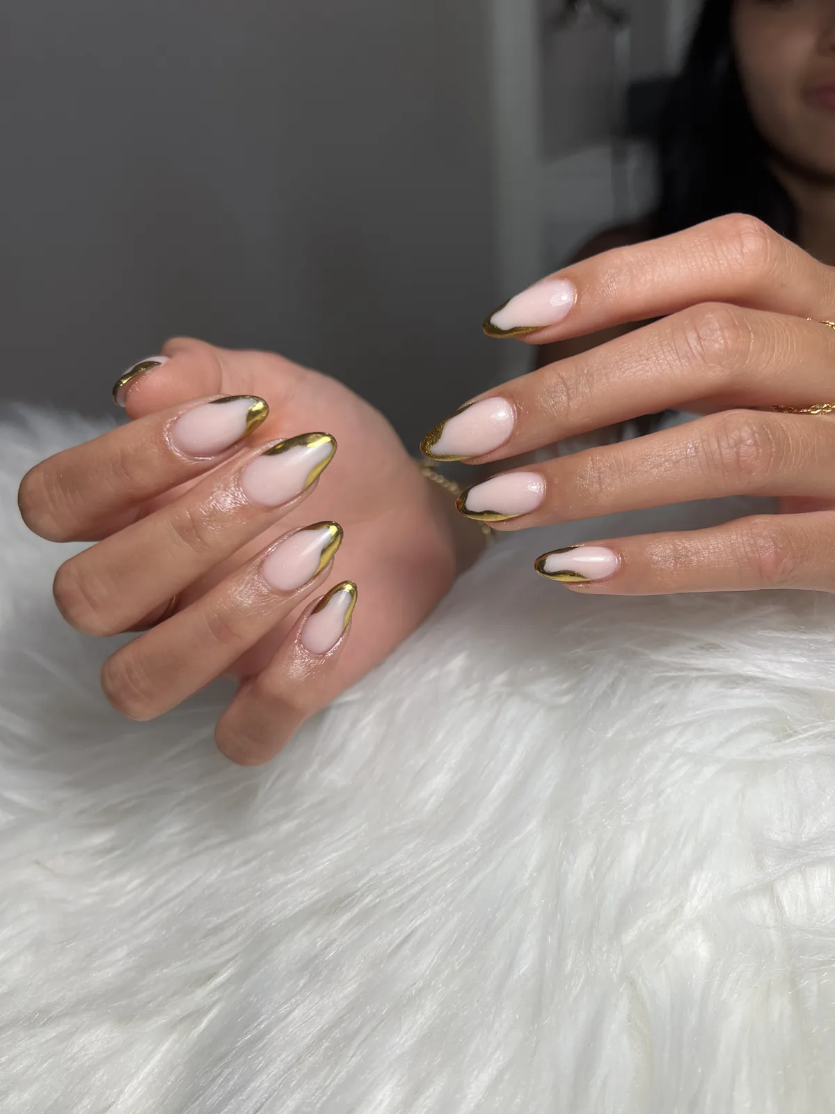 Nude almond nails with abstract gold chrome French swooshes