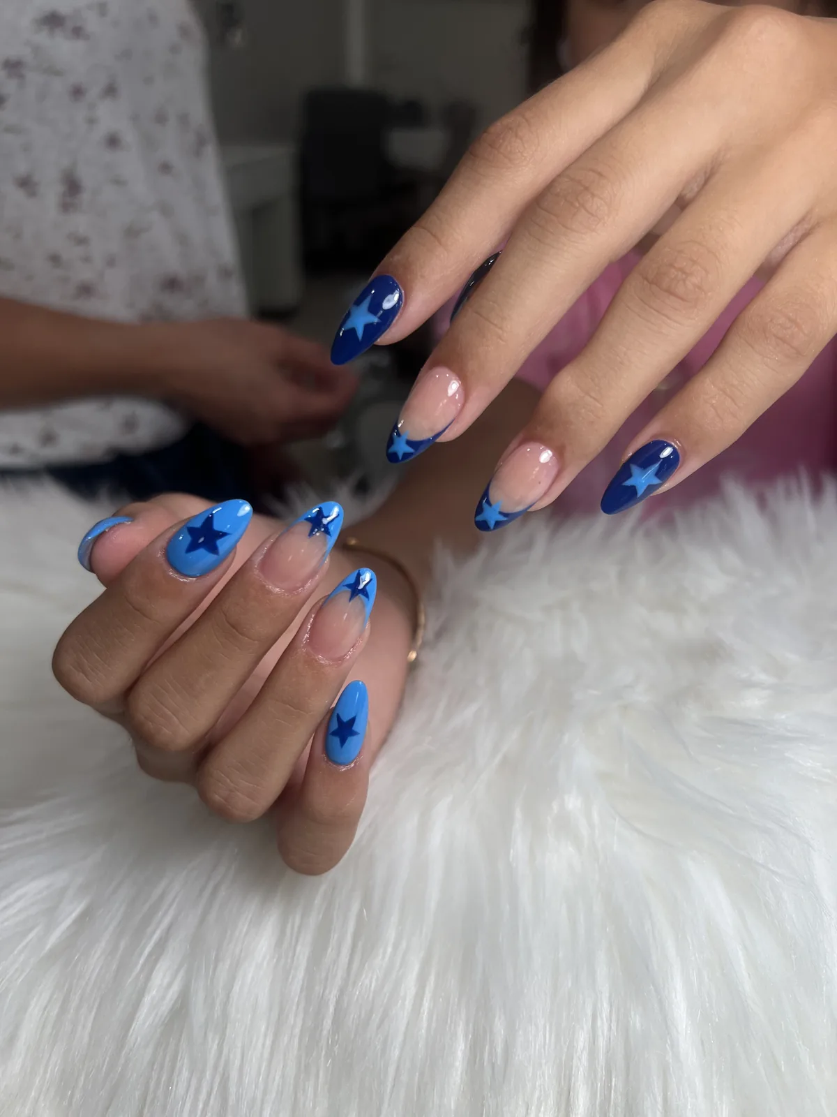 Royal and sky blue almond nails with hand-painted star accents