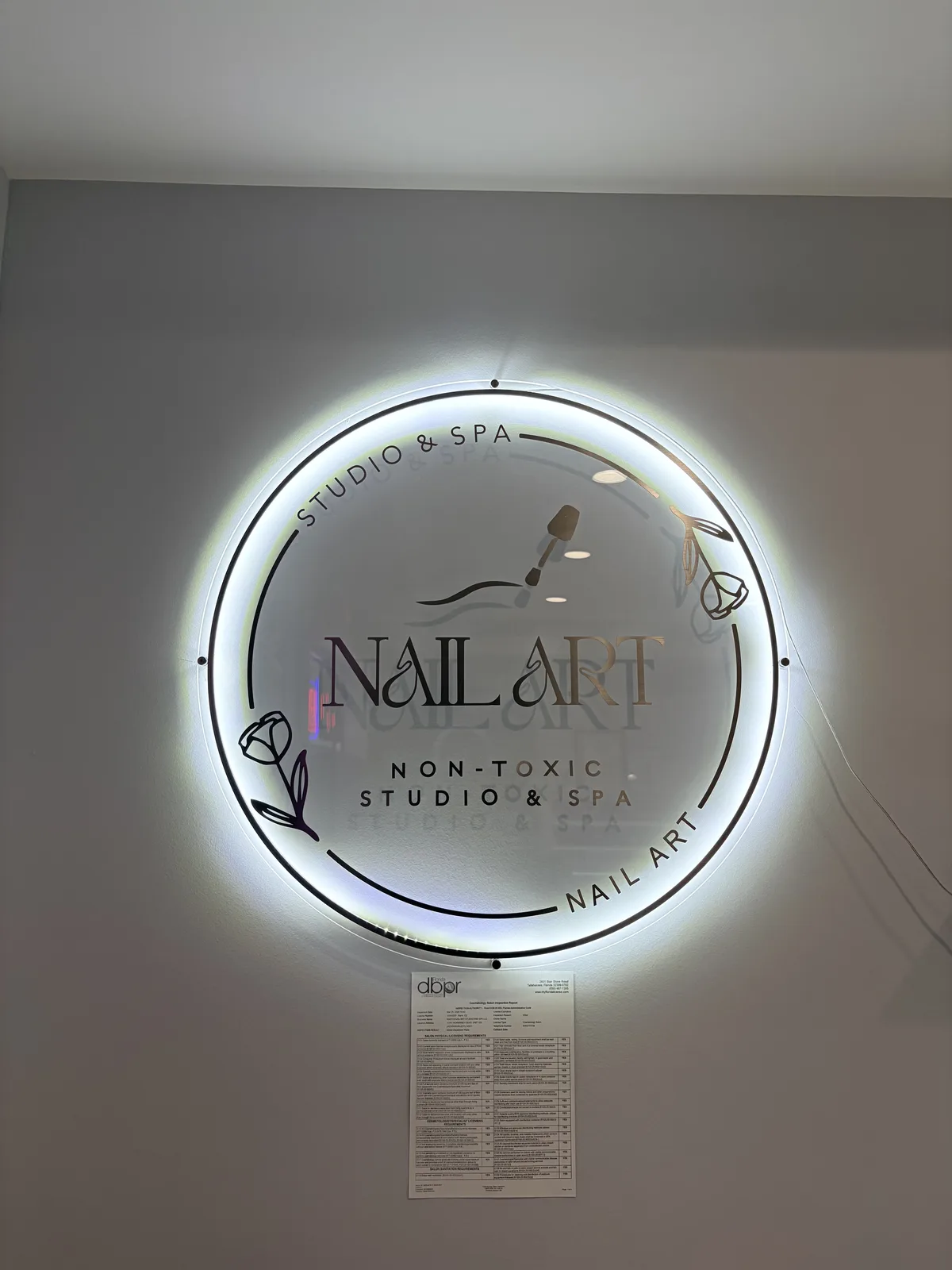 Backlit signage reading 'Nail Art — Non-Toxic Studio & Spa' inside the salon